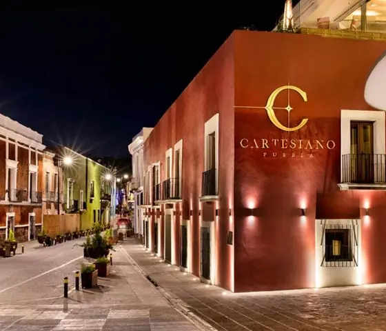Fachada del Hotel Cartesiano iluminada de noche