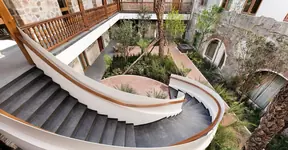 Escalera de caracol y patio con arcos del Hotel Cartesiano